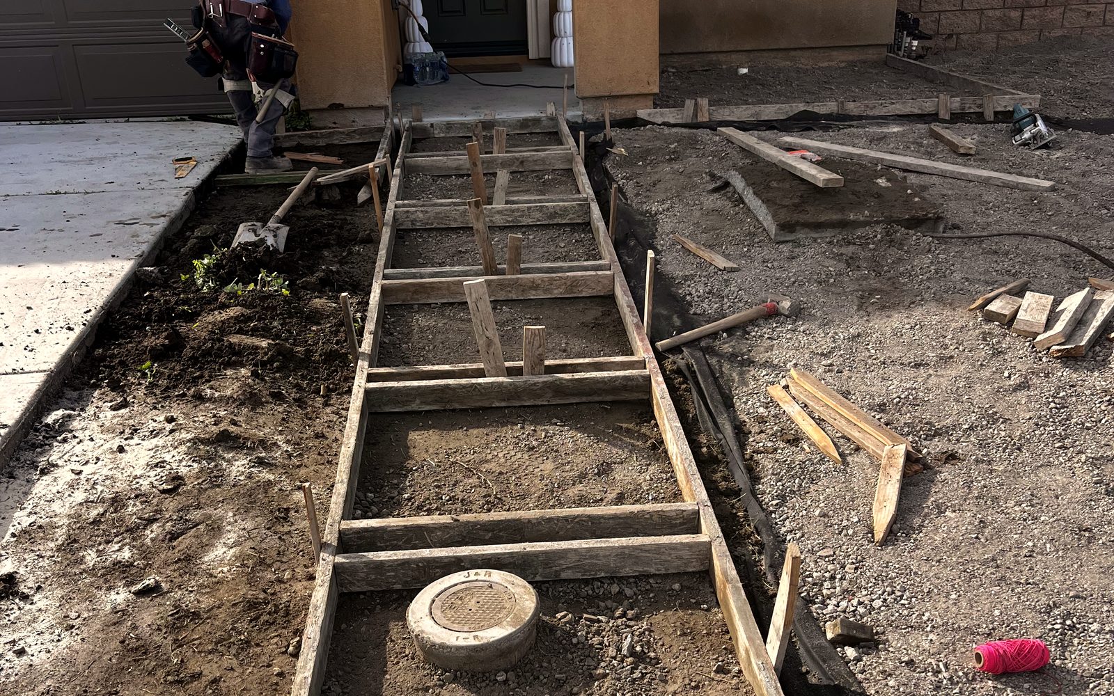 Front yard before the pour: wood forms staked out for a stepped walkway to the door