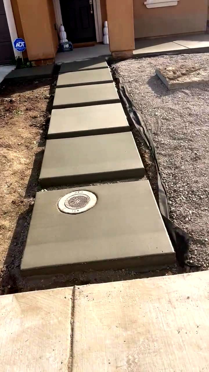 Finished floating concrete step walkway leading to a new home's front door