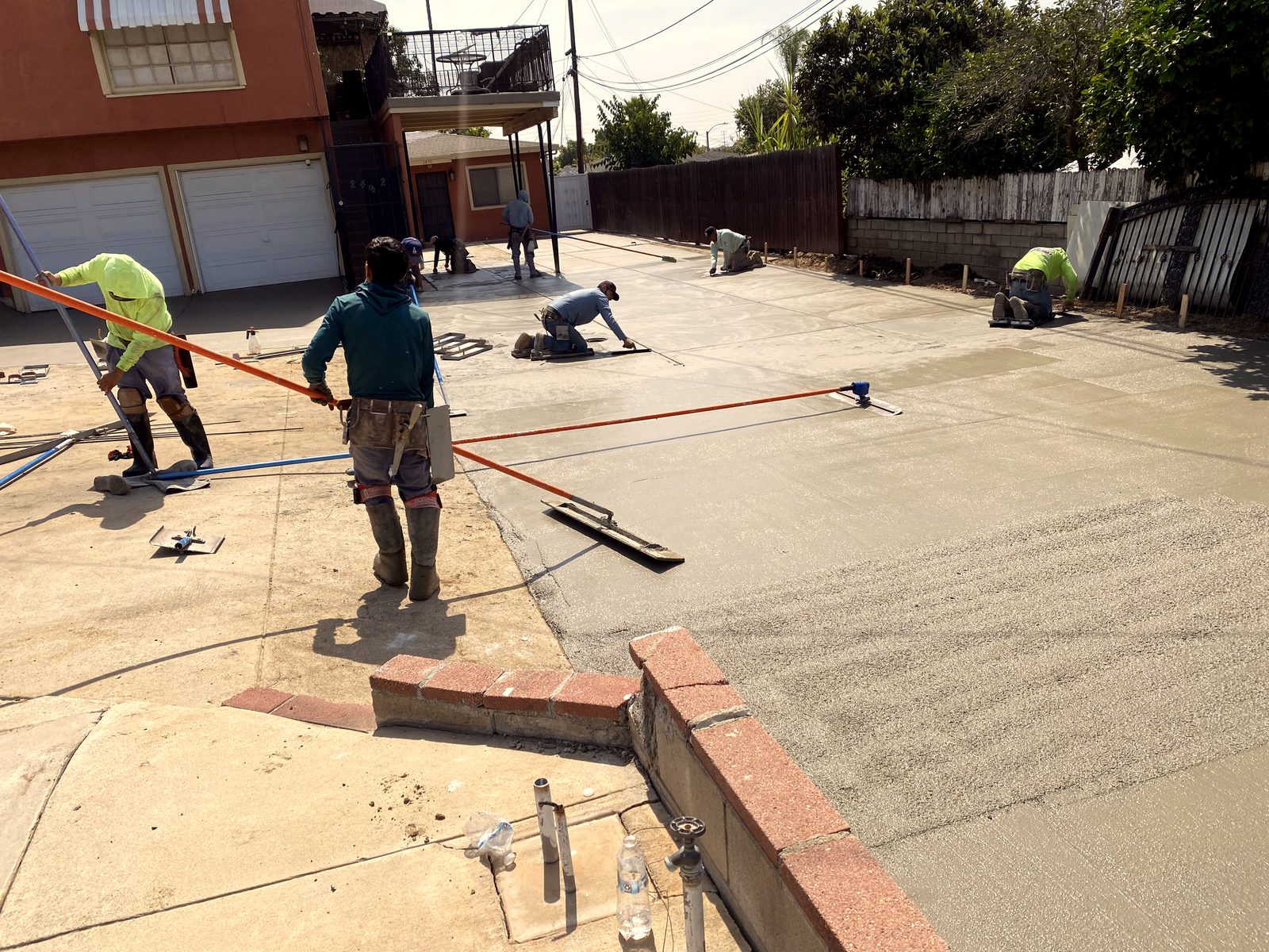 The crew floating and finishing a large fresh concrete slab