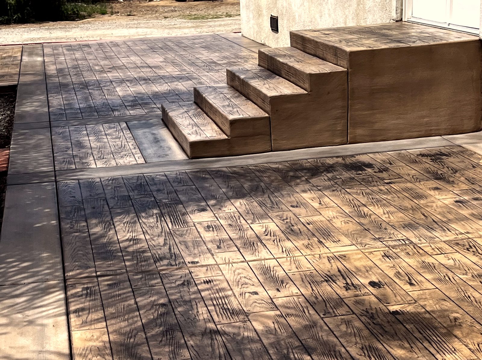 Wood-plank stamped concrete patio with matching stamped steps